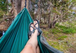 Frau mit Sandalen in der Hängematte